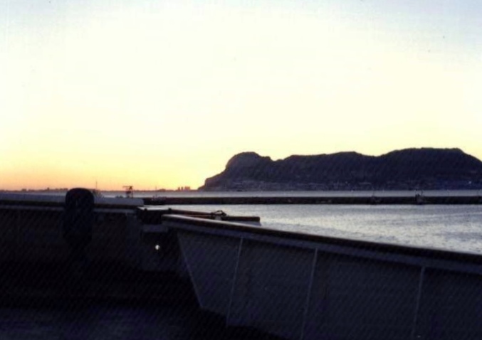 Rock of Gibraltar in distance; deck in foreground; sea between